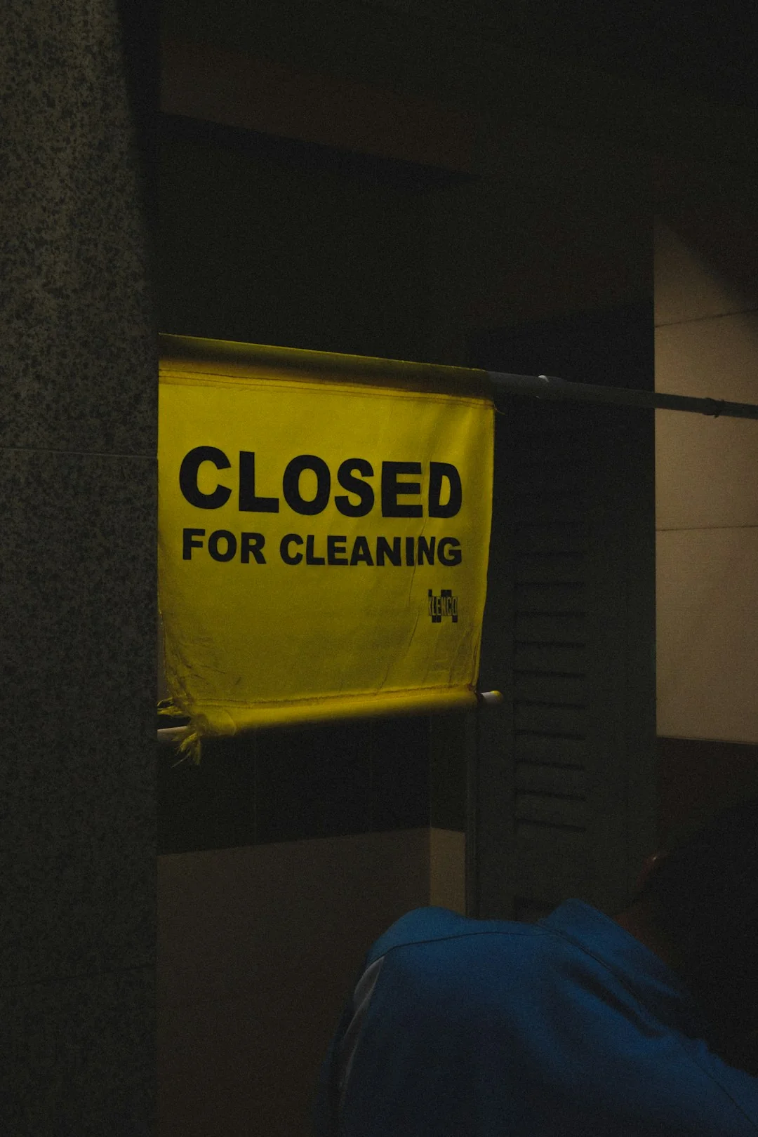 Person using spray bottle and cloth for cleaning a kitchen shelf, ensuring hygiene and cleanliness.